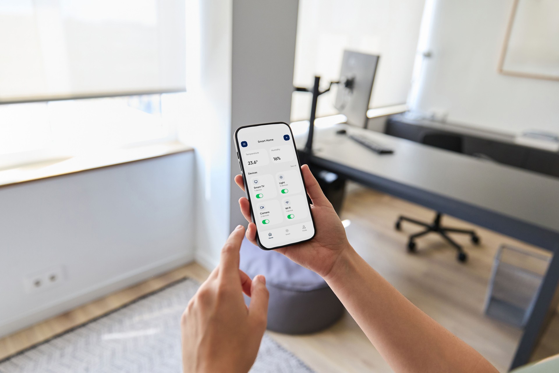 Mujer usando la aplicación de teléfono inteligente para controlar dispositivos domésticos inteligentes, ajustando la configuración de luces, temperatura y otros electrodomésticos