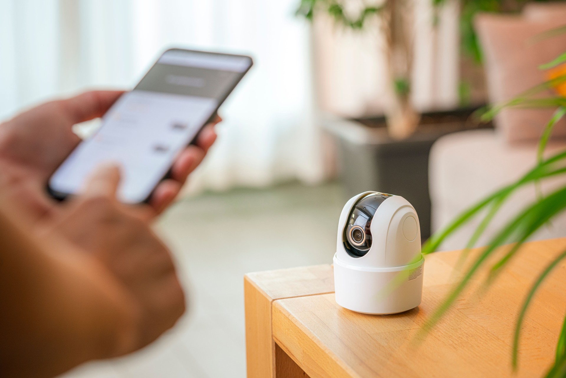 Persona ajustando la cámara de seguridad CCTV inalámbrica mediante la aplicación móvil.